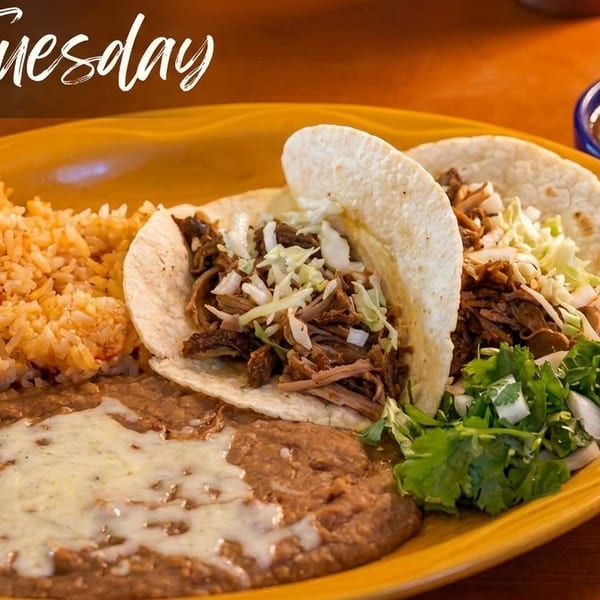 Two tacos with shredded meat and cabbage, rice, refried beans, and salsa on a yellow plate.
