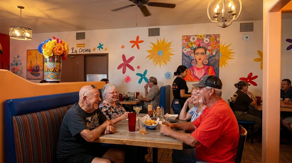 Diners enjoying meals in a vibrant Mexican restaurant with colorful murals and decor.